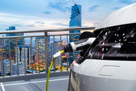 Electric car charging on parking lot of rooftop buildingの写真素材