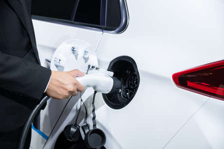 Businessman charging an electric vehicleの写真素材