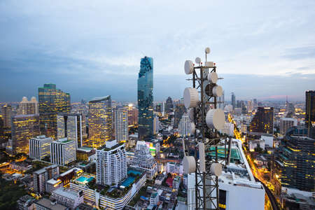 Telecommunication tower with 5G cellular network antenna on city backgroundの写真素材