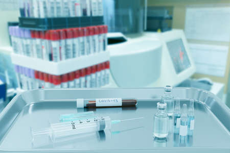 Vaccine and syringe injection with blood sample in laboratory
for prevention and treatment corona virus infection (COVID-19, nCoV 2019), Medical concept.の写真素材
