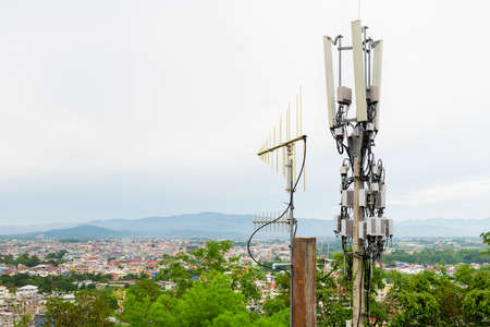 Telecommunication tower with 5G cellular network antenna on A town in the valley backgroundの写真素材