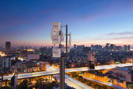 Telecommunication tower with 5G cellular network antenna on night city background