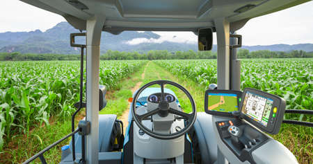 5G autonomous tractor working in corn field, Future technology with smart agriculture farming conceptの写真素材