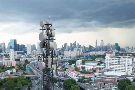 Telecommunication tower with 5G cellular network antenna on city backgroundの写真素材