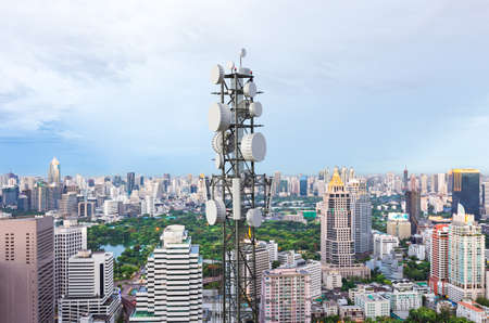 Telecommunication tower with 5G cellular network antenna on city backgroundの写真素材