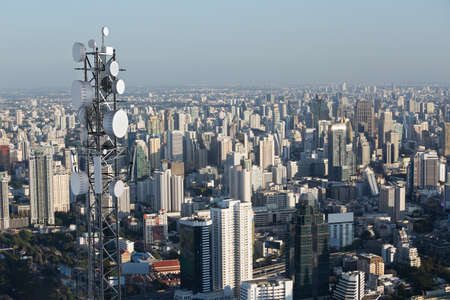 Telecommunication tower with 5G cellular network antenna on city background