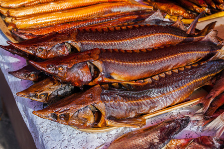 Smoked sterlets at the fish market on Volga river. Eels in the backgroundの写真素材