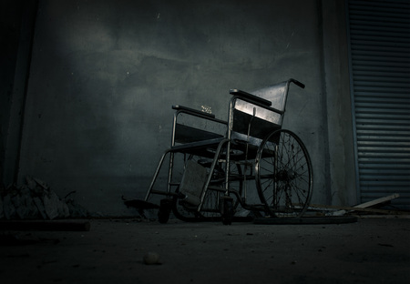 an old wheelchair in old room. old wheelchair was forsaken. this is lonely and scary concept.の写真素材