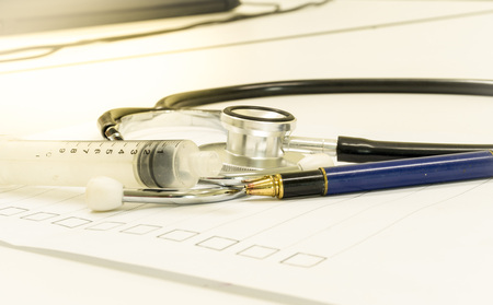 medical equipment at doctor's workplace. stethoscope and syringe.の写真素材