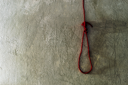 red rope noose for death on cement wall の写真素材