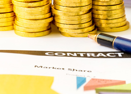 business concept with golden coin and contract paperの写真素材