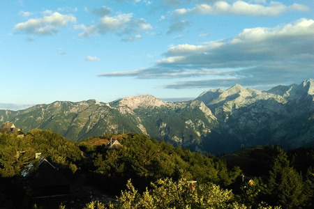 A view of the mountains with green trees and a beautiful sky.の写真素材