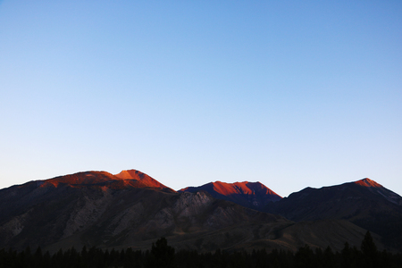 Orange peaks of mountains during sunset, background.の写真素材