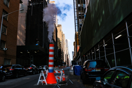 NEW YORK, USA - August 30, 2018: Low angle view of steam coming out stack for venting the district heating system in downtown of New Yorkのeditorial素材