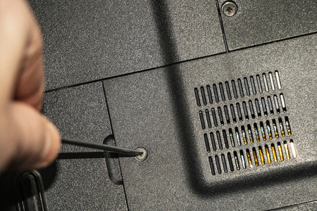 Repairing old laptop PC. Person repairs old PC, disassembles its parts and does maintenance