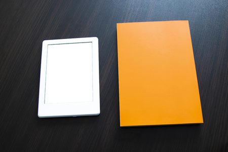 E-book and paper book on the table. Concepts of self-education.You can add your own text or imageの写真素材