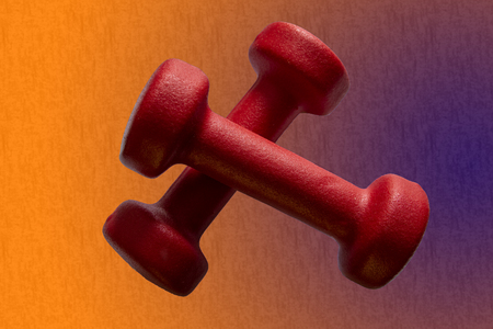 Red dumbbells on a beautiful background isolated in the gymの写真素材