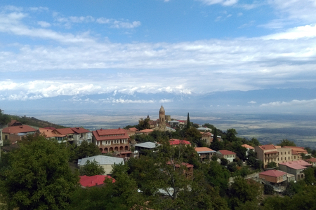 Sighnaghi city of love in Georgia, Kakheti region. Red roofs of houses and brick towers of the cathedral and fortress, blue sky and green trees backgroundの写真素材