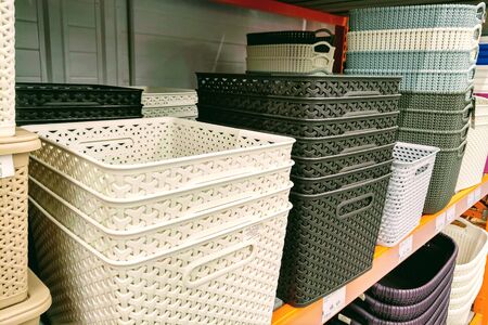 Colorful plastic boxes stacked one upon the other. Multi-colored plastic baskets on the store shelfの写真素材