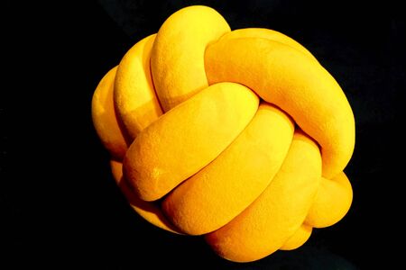 Decorative soft yellow toy on a black background