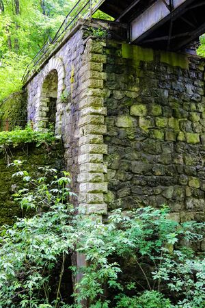 The pillar of the old bridge of stones surrounded by forest. soft focus, lack of focusの写真素材