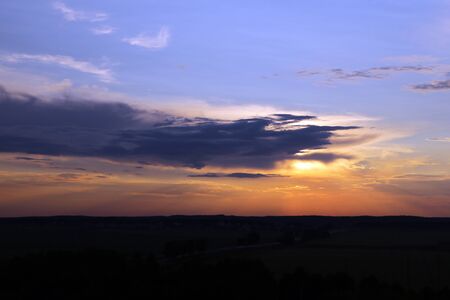 Beautiful sunset sky above clouds with dramatic lightの写真素材