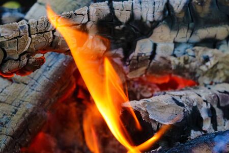 Beautiful color of burning red coals and black charred wood. Orange hot coals in the Russian stove. Red burning coals as a texture for designの写真素材