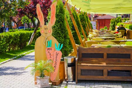 Sighisoara, Romania, May 13, 2019: Funny sign in a cafe on the terrace in the form of hares. Out of focus cafe visitorsのeditorial素材