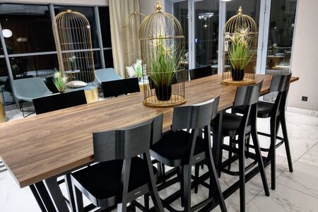 View of a high table with chairs, lamps hang above the table, interior background, out of focusの写真素材