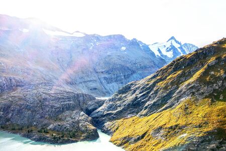Beautiful view of alpine mountains, mountain peaks in the fog, nature background, fresh clean air, mountains in Austria, out of focusの写真素材