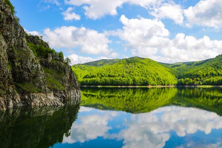 Nice view of the mountains and green hills. Reflection of hills in a lakeの写真素材