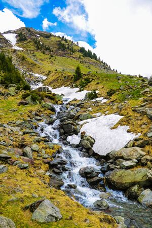 Mountain stream flows on a mountain slope, selective focusの写真素材