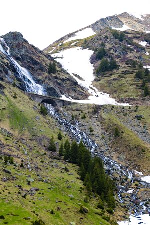 Mountain stream flows along the mountainside, snow. Nature background in spring or summer. Selective focusの写真素材