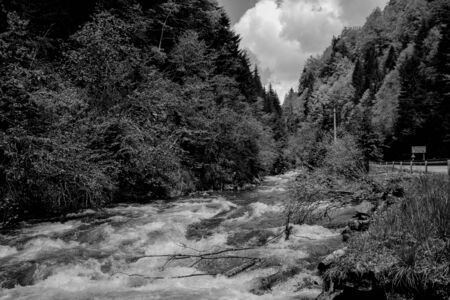 Black and white photo of a mountain fast cold riverの写真素材