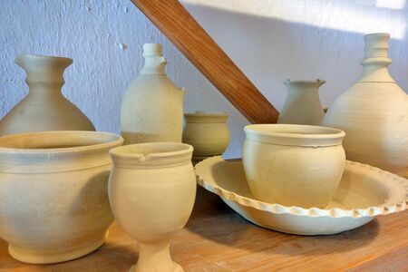 Plates, cups, clay dishes close up. Do-it-yourself ceramic dishes on local marketの写真素材