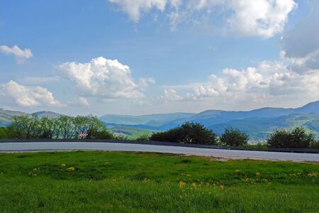 View of the mountain road, blue sky, mountains on the horizon.の写真素材