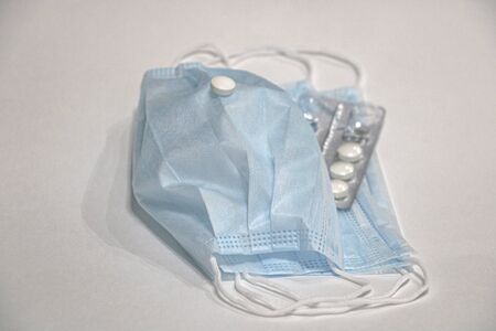 A face mask and white tablets. Coronavirus conceptの写真素材