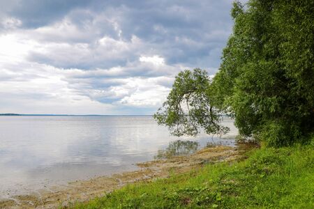 Shore of a large lake or sea on a cloudy dayの写真素材