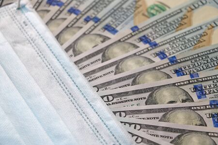 Medical mask laying on dollars. Coronavirus or Covid19の写真素材