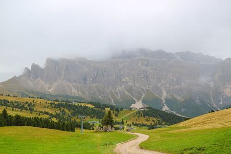 Picturesque landscape of foggy morning in mountain village in Dolomites Alps, selective focusの写真素材