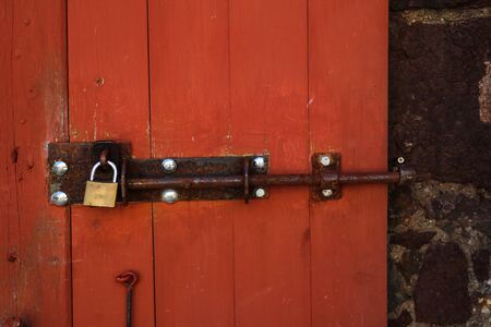 Old rusty lock on a red wooden doorの写真素材