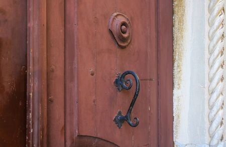 Iron black doorknob against the background of red doorsの写真素材