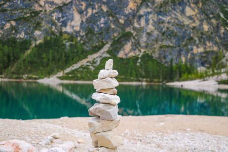 Stone tower made by tourists by the lakeの写真素材