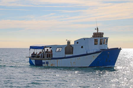 People are sailing on an old boat. Violation of water boundariesの写真素材