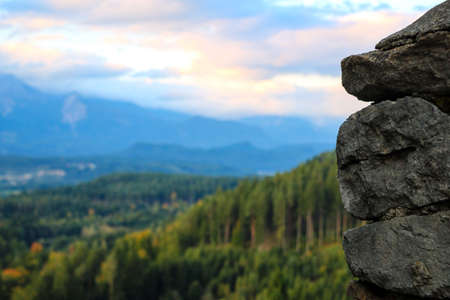 Close-up view of a part of a stone wall. Mountains and green forestの写真素材
