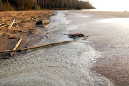 Foam on the surf of the waves on the shore of the lakeの写真素材