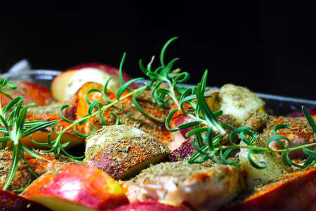 A branch of green rosemary on pieces of meat and applesの写真素材