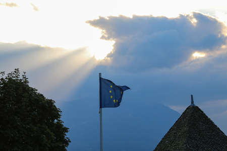 European union flag waving in the wind against the backdrop of the sunsetの写真素材