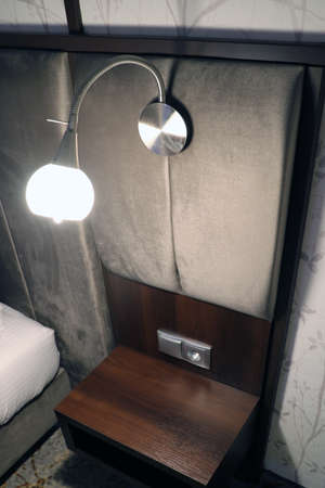 Comfortable modern lamp above the bedside table in the bedroomの写真素材