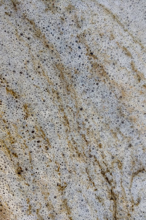Vertical photo. The texture of the foam on the seashore from the surfの写真素材